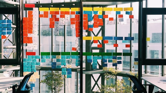 Bureau moderne avec des post-it collés sur un mur en verre