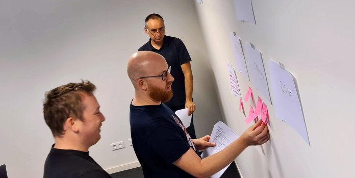 L'équipe colle des post-it sur le mur
