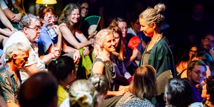Foule animée lors d'un concert, ambiance chaleureuse avec lumières tamisées.