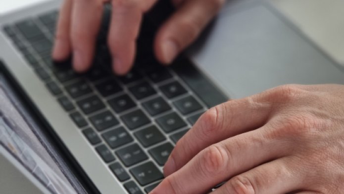 Deux mains sur un clavier d'ordinateur portable