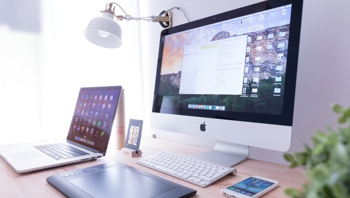Desk with computer, laptop, phone and Apple tablet